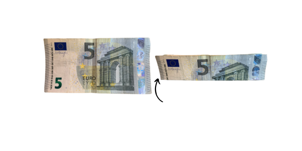 Fünf-Euro-Schein, der längsseitig geknickt um später zu einem Herz gefaltet wird.